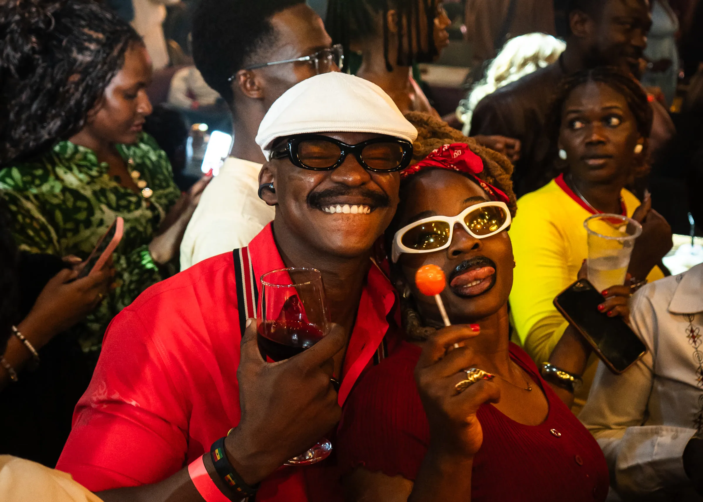 Two guests in red, a glass of wine and a lollipop